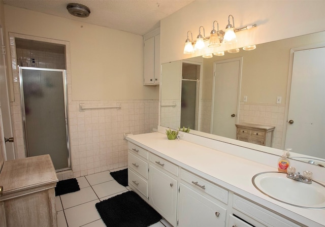 1217 Randy Dr, Graham, TX 76450 - bathroom featuring tile walls, tile patterned flooring, a stall shower, wainscoting, and vanity