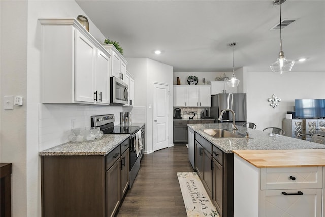 6213 Bracken Dr, Celina, TX 76227 - kitchen with appliances with stainless steel finishes, a sink, dark wood-style flooring, a kitchen island with sink, and white cabinetry