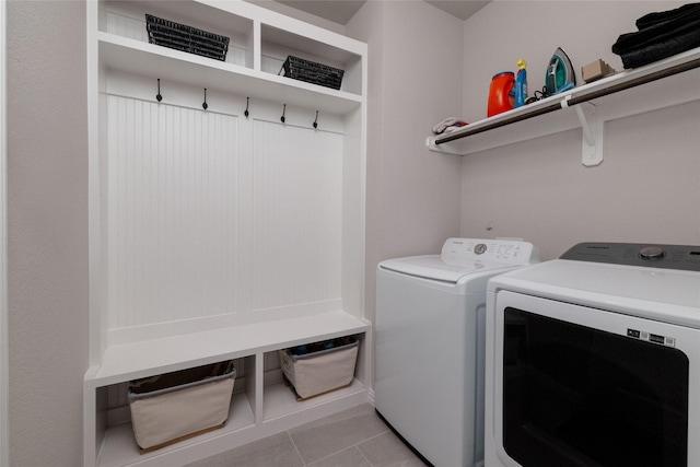 1705 Surrey Ct, Weatherford, TX 76087 - clothes washing area with washer and clothes dryer and light tile patterned floors