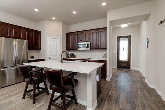 1705 Surrey Ct, Weatherford, TX 76087 - kitchen featuring stainless steel appliances, a sink, light countertops, decorative backsplash, and recessed lighting