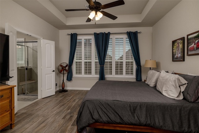 1705 Surrey Ct, Weatherford, TX 76087 - bedroom with a tray ceiling, wood finished floors, ensuite bathroom, baseboards, and ceiling fan