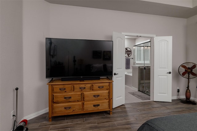 1705 Surrey Ct, Weatherford, TX 76087 - bedroom featuring wood tiled floors, baseboards, and connected bathroom