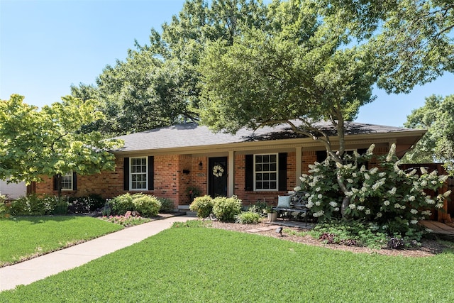 ranch-style house with a front lawn, brick siding, and a porch