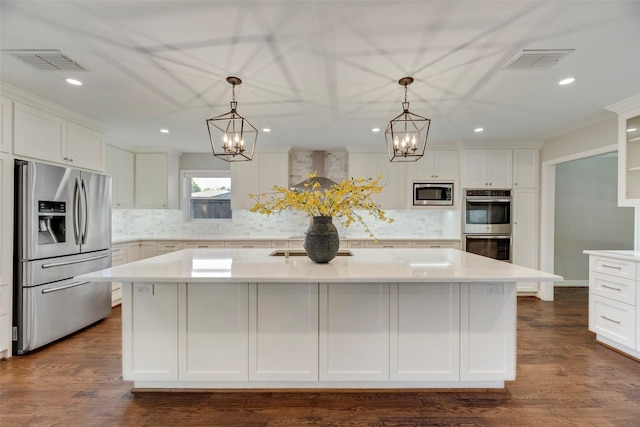 7324 Heathermore Dr, Dallas, TX 75248 - kitchen featuring appliances with stainless steel finishes, a chandelier, light countertops, white cabinets, and recessed lighting
