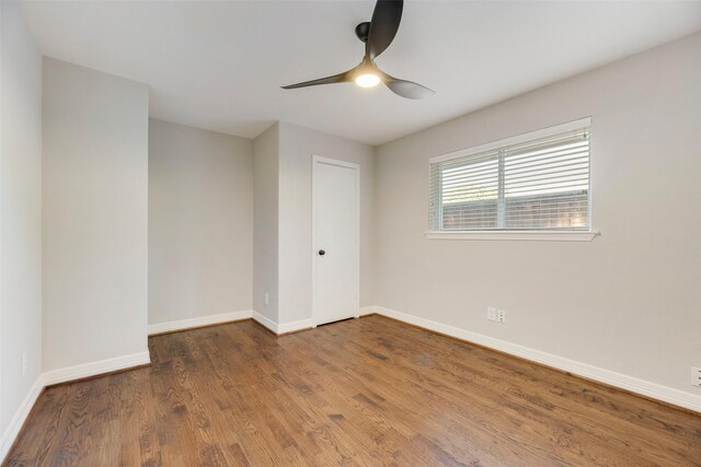 spare room featuring wood finished floors, baseboards, and ceiling fan