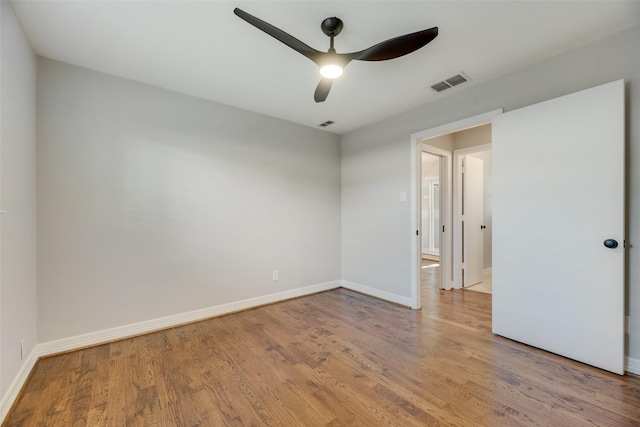 spare room featuring a ceiling fan, wood finished floors, and baseboards