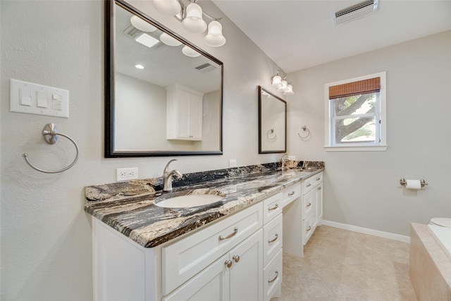 bathroom with double vanity, tile patterned floors, and baseboards