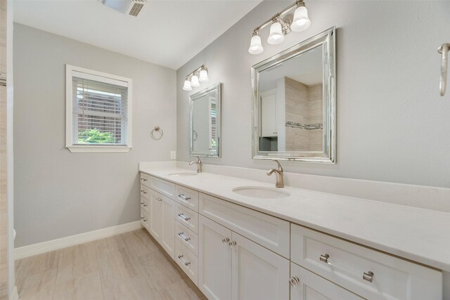 bathroom featuring double vanity and baseboards