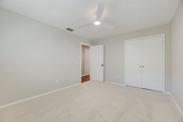 unfurnished bedroom featuring carpet floors, baseboards, a ceiling fan, and a closet