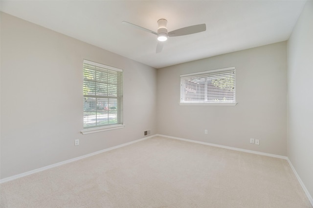 unfurnished room featuring light colored carpet, ceiling fan, and baseboards