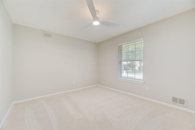spare room with light colored carpet, ceiling fan, and baseboards