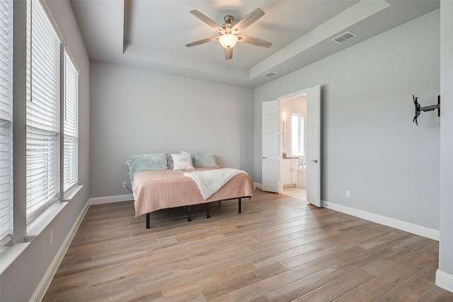 14312 Home Trl, Fort Worth, TX 76262 - bedroom featuring a tray ceiling, light wood finished floors, baseboards, and connected bathroom