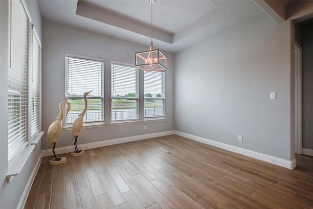 14312 Home Trl, Fort Worth, TX 76262 - spare room with wood finished floors, a chandelier, a tray ceiling, and baseboards
