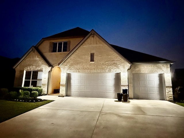 14312 Home Trl, Fort Worth, TX 76262 - french country home with concrete driveway, an attached garage, and stucco siding