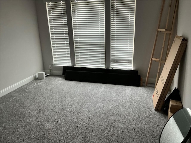 carpeted empty room featuring baseboards