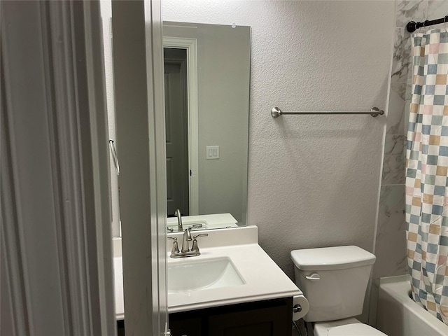 full bathroom featuring vanity, toilet, a textured wall, and shower / tub combo