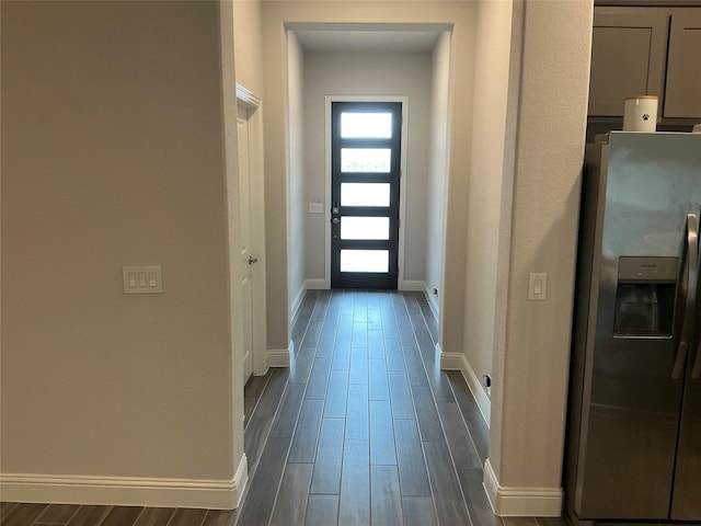 entryway featuring baseboards and dark wood finished floors