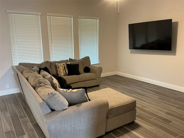 living area with baseboards and dark wood-type flooring