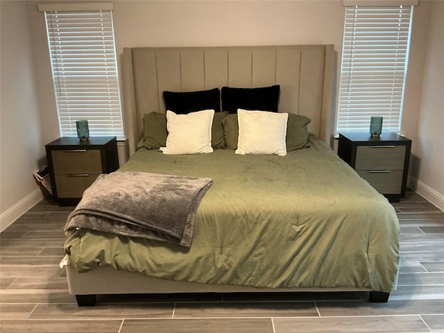 bedroom with baseboards and wood finish floors