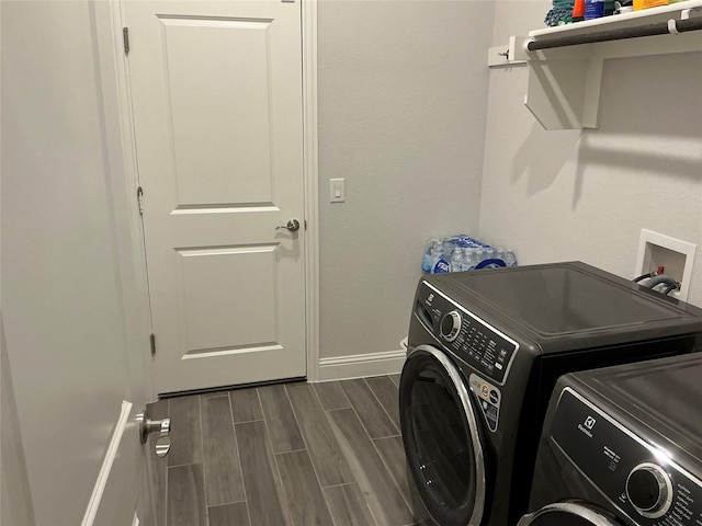 laundry room featuring separate washer and dryer, baseboards, and wood finish floors