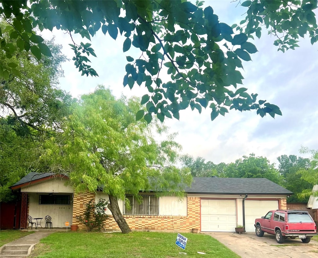view of front of house featuring an attached garage, brick siding, driveway, a front lawn, and a shingled roof