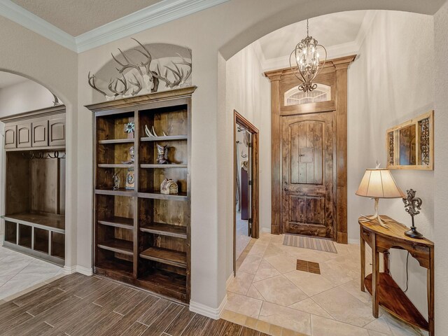129 Spring Meadow Dr, Springtown, TX 76082 - mudroom featuring arched walkways, a chandelier, ornamental molding, wood finished floors, and baseboards