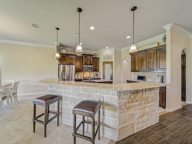 129 Spring Meadow Dr, Springtown, TX 76082 - kitchen featuring stainless steel appliances, a spacious island, tasteful backsplash, ornamental molding, and baseboards