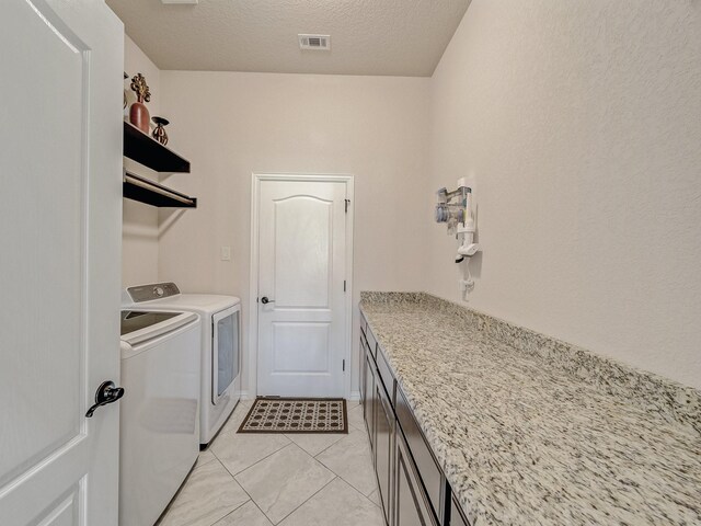 129 Spring Meadow Dr, Springtown, TX 76082 - washroom with independent washer and dryer, light tile patterned floors, a textured ceiling, and cabinet space