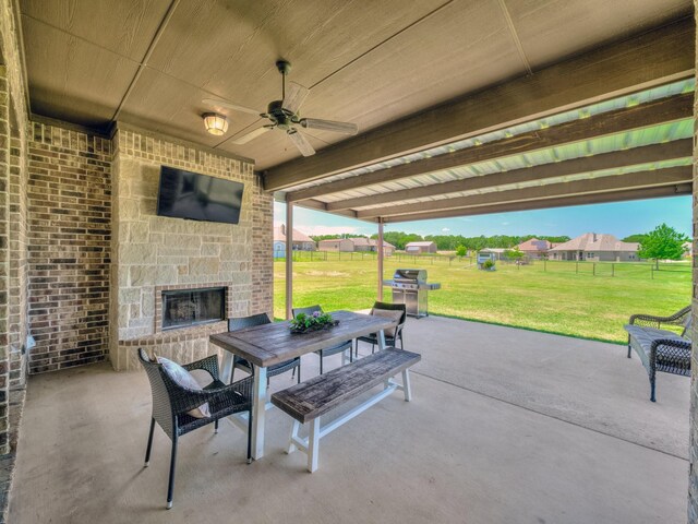 129 Spring Meadow Dr, Springtown, TX 76082 - view of patio with an outdoor stone fireplace, outdoor dining space, a ceiling fan, and grilling area