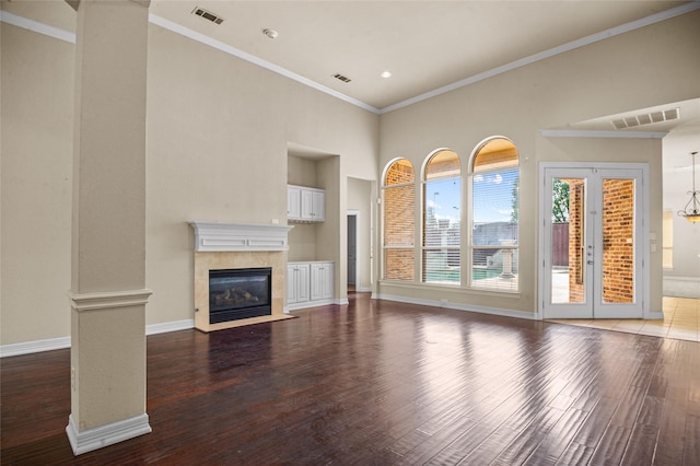17 Wimbledon Ct, Heath, TX 75032 - unfurnished living room featuring wood finished floors, a tiled fireplace, baseboards, a high ceiling, and ornamental molding