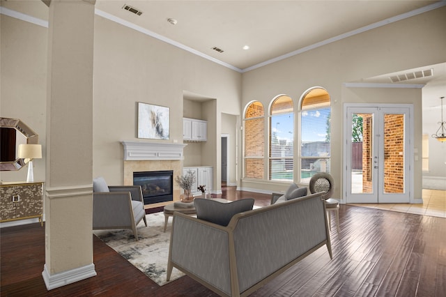 17 Wimbledon Ct, Heath, TX 75032 - living area with a tiled fireplace, hardwood / wood-style floors, a towering ceiling, crown molding, and baseboards