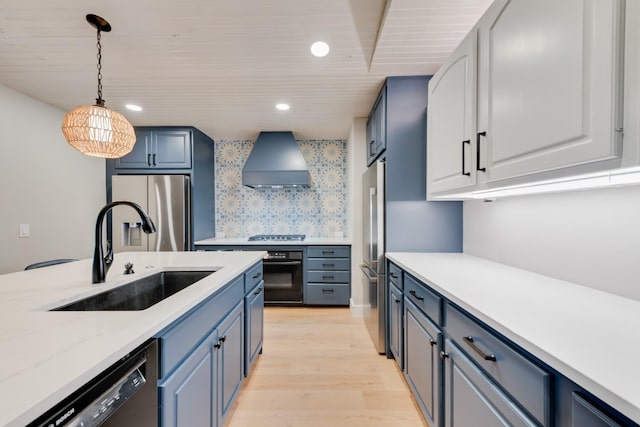9 Southshore Cir, Star Harbor, TX 75148 - kitchen with stainless steel appliances, a sink, custom exhaust hood, light wood-style floors, and blue cabinets