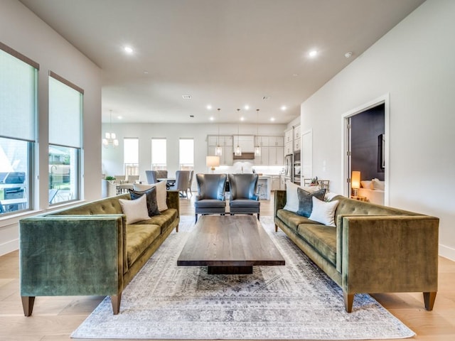 4208 Sunrise Ln, Celina, TX 75078 - living room with recessed lighting, baseboards, light wood-style floors, and a chandelier