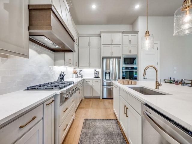 4208 Sunrise Ln, Celina, TX 75078 - kitchen featuring stainless steel appliances, a sink, premium range hood, decorative light fixtures, and white cabinetry
