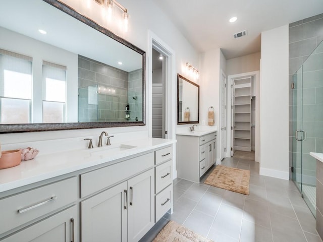 4208 Sunrise Ln, Celina, TX 75078 - bathroom with a shower stall, a spacious closet, two vanities, tile patterned floors, and recessed lighting