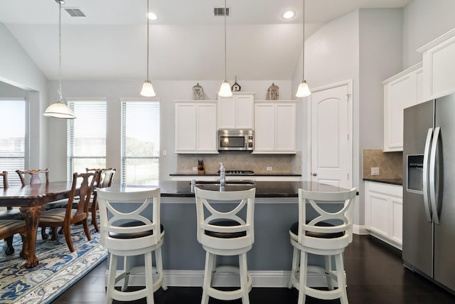 804 Countryside Way, Little Elm, TX 76227 - kitchen with appliances with stainless steel finishes, lofted ceiling, dark countertops, tasteful backsplash, and white cabinetry