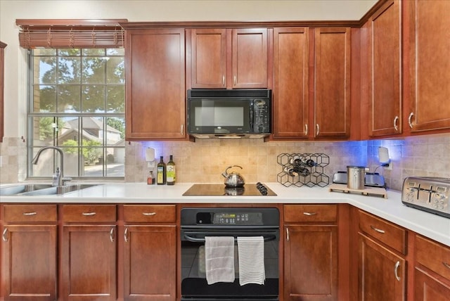 2652 Waterway Dr, Grand Prairie, TX 75054 - kitchen with black appliances, a sink, light countertops, tasteful backsplash, and brown cabinetry