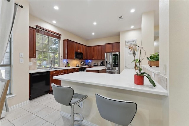 2652 Waterway Dr, Grand Prairie, TX 75054 - kitchen featuring black appliances, a sink, a peninsula, backsplash, and light countertops