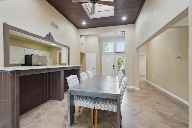 dining area featuring a high ceiling, ceiling fan, light tile patterned floors, baseboards, and recessed lighting