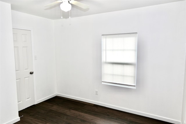 unfurnished room with dark wood-type flooring, ceiling fan, and baseboards
