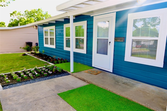 doorway to property featuring a lawn and a patio area