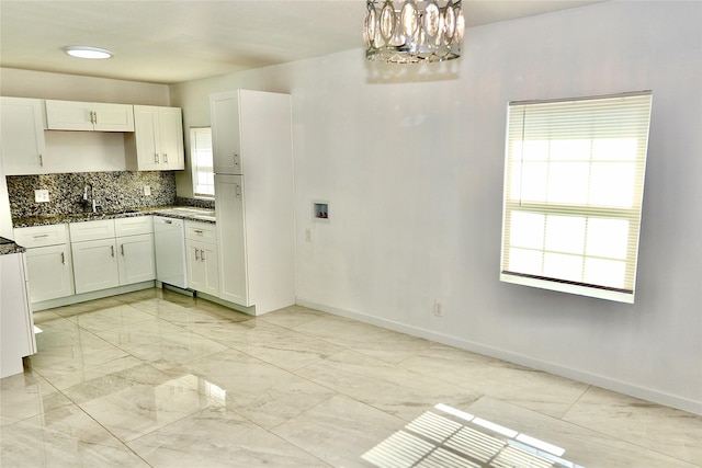 kitchen featuring dishwasher, a chandelier, decorative backsplash, dark stone counters, and white cabinetry