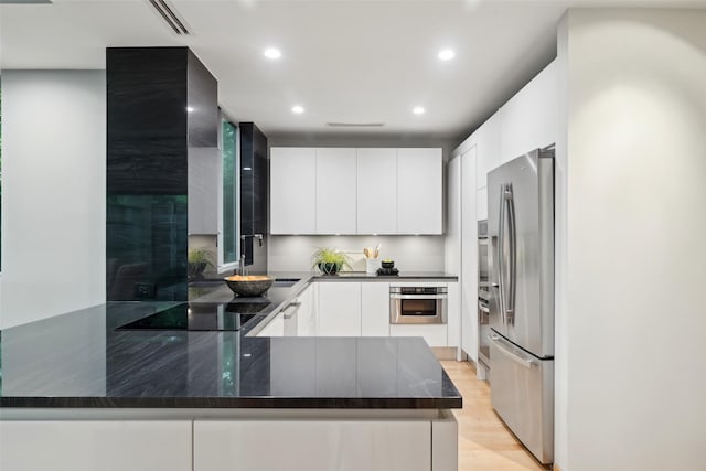 957 Easton Pl, Dallas, TX 75218 - kitchen with stainless steel appliances, modern cabinets, a peninsula, white cabinetry, and recessed lighting