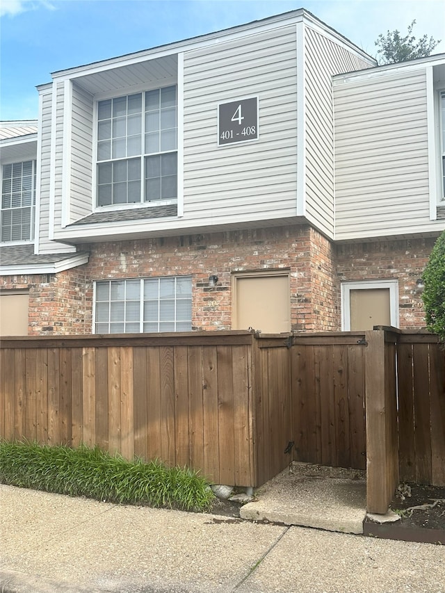 12921 Abrams Rd Unit 407, Dallas, TX 75243 - view of property exterior featuring brick siding and fence
