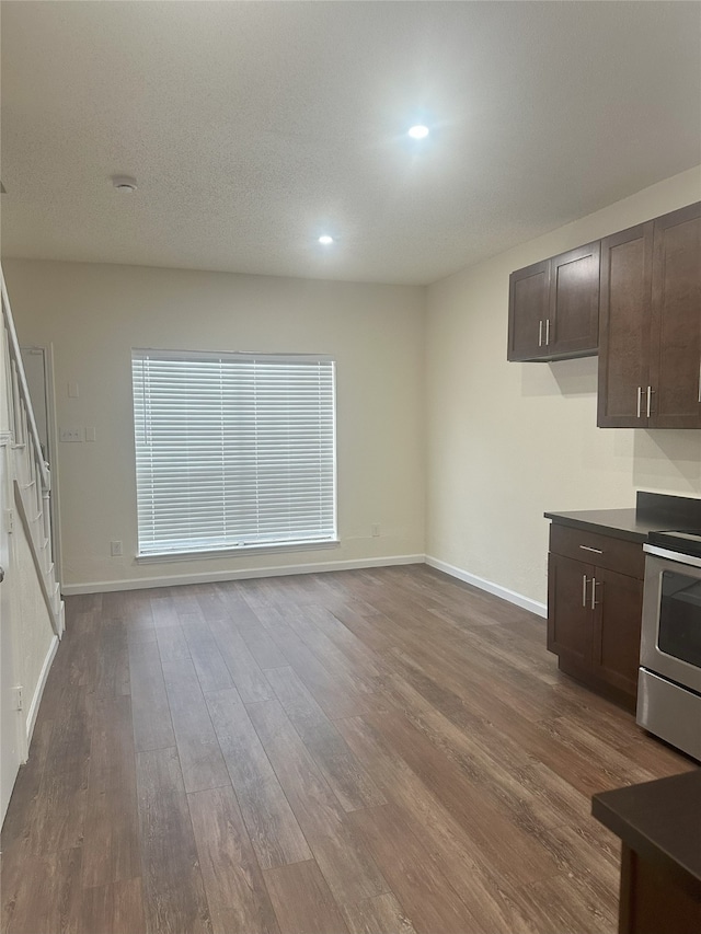 12921 Abrams Rd Unit 407, Dallas, TX 75243 - unfurnished living room with dark wood-style flooring, baseboards, stairway, and recessed lighting