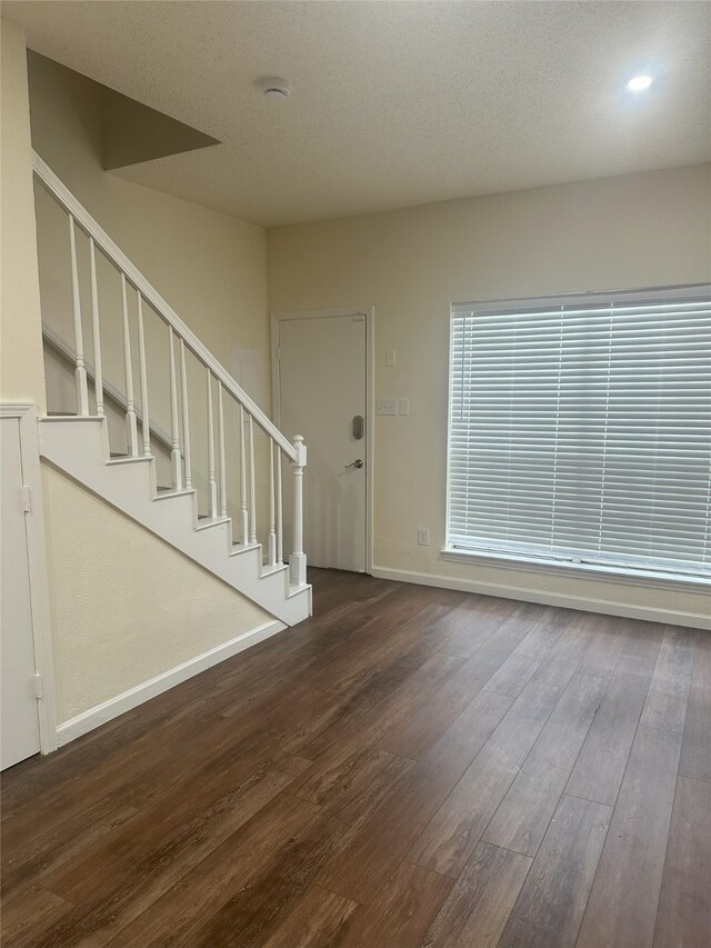 12921 Abrams Rd Unit 407, Dallas, TX 75243 - unfurnished living room with dark wood-style floors, baseboards, stairway, and recessed lighting