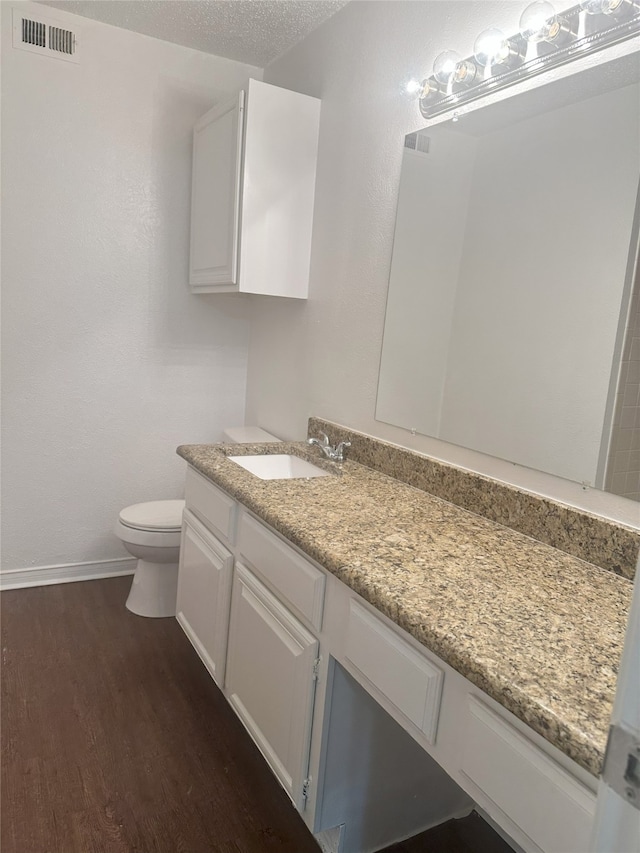 12921 Abrams Rd Unit 407, Dallas, TX 75243 - bathroom with wood finished floors, vanity, baseboards, and toilet