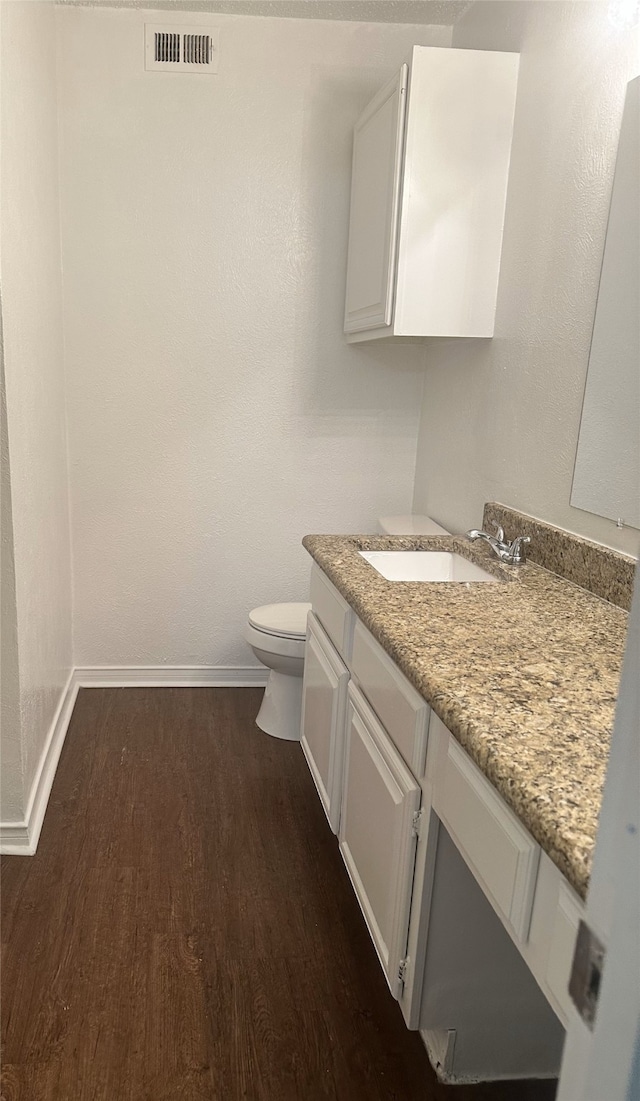 12921 Abrams Rd Unit 407, Dallas, TX 75243 - bathroom with wood finished floors, baseboards, vanity, and toilet