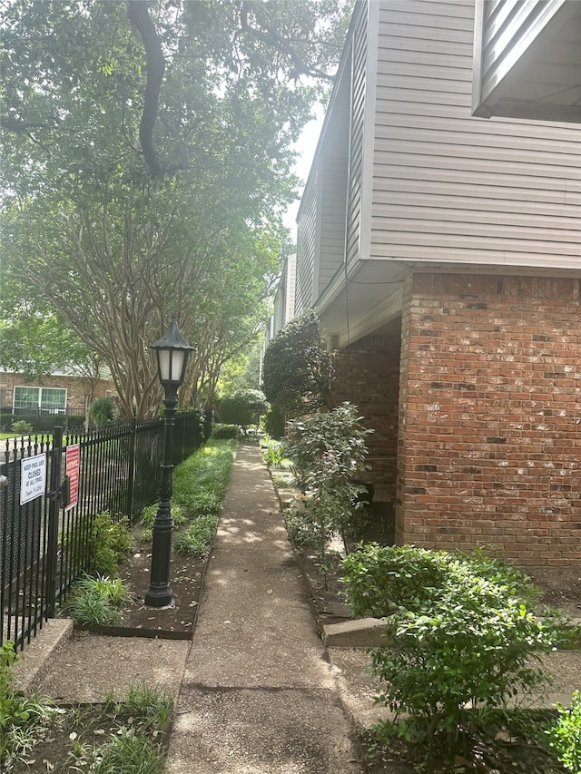 12921 Abrams Rd Unit 407, Dallas, TX 75243 - view of property exterior featuring fence and brick siding