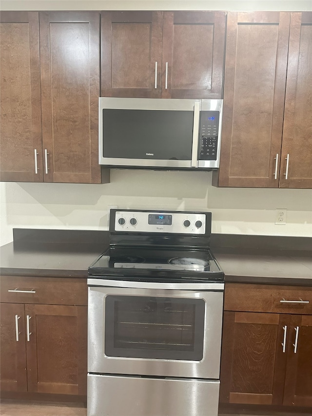12921 Abrams Rd Unit 407, Dallas, TX 75243 - kitchen with appliances with stainless steel finishes, dark countertops, and dark brown cabinetry